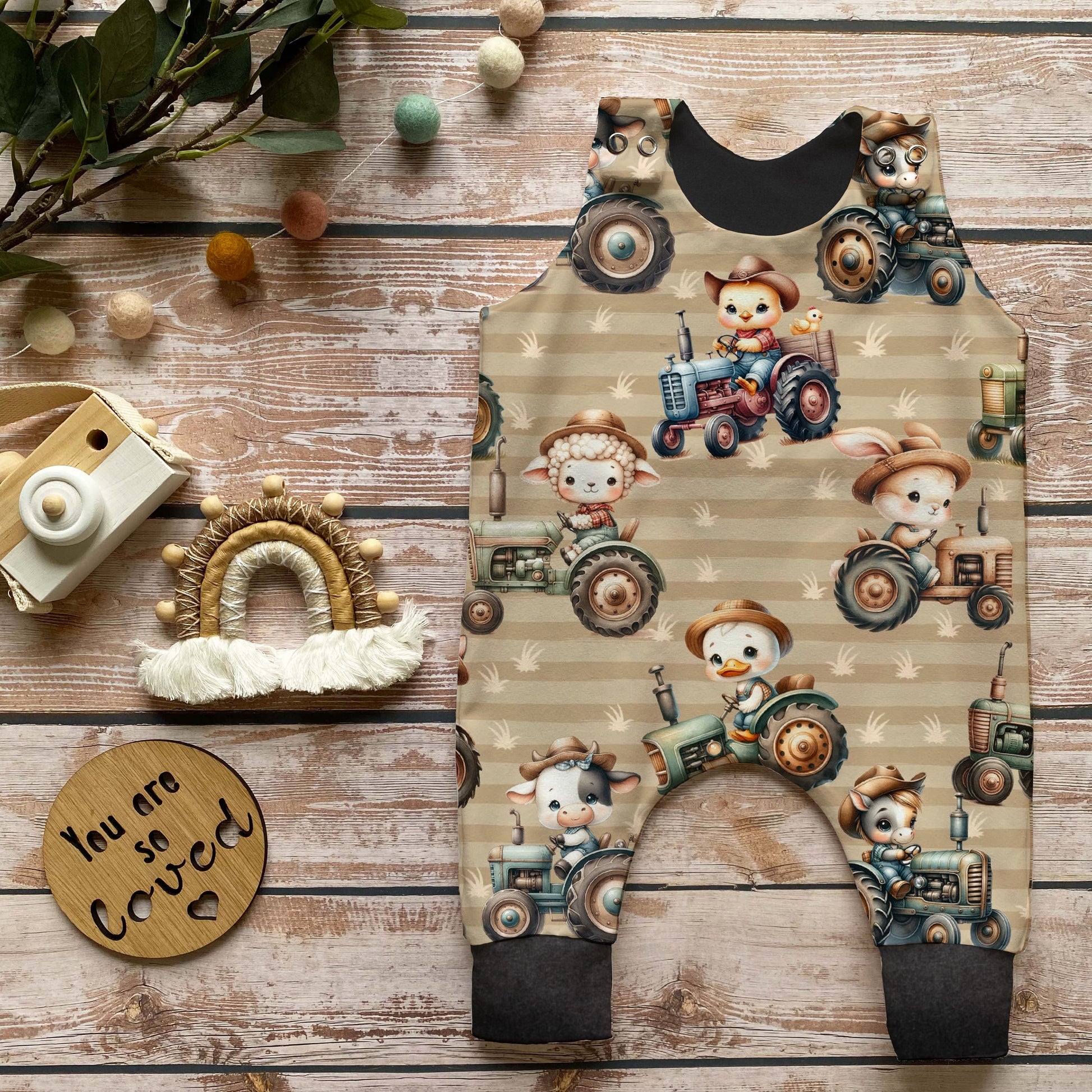 Nahaufnahme Baby Strampler mit Bauernhof-Traktor-Print, süße Bauernhoftiere wie Küken, Lamm, Hase und Kuh