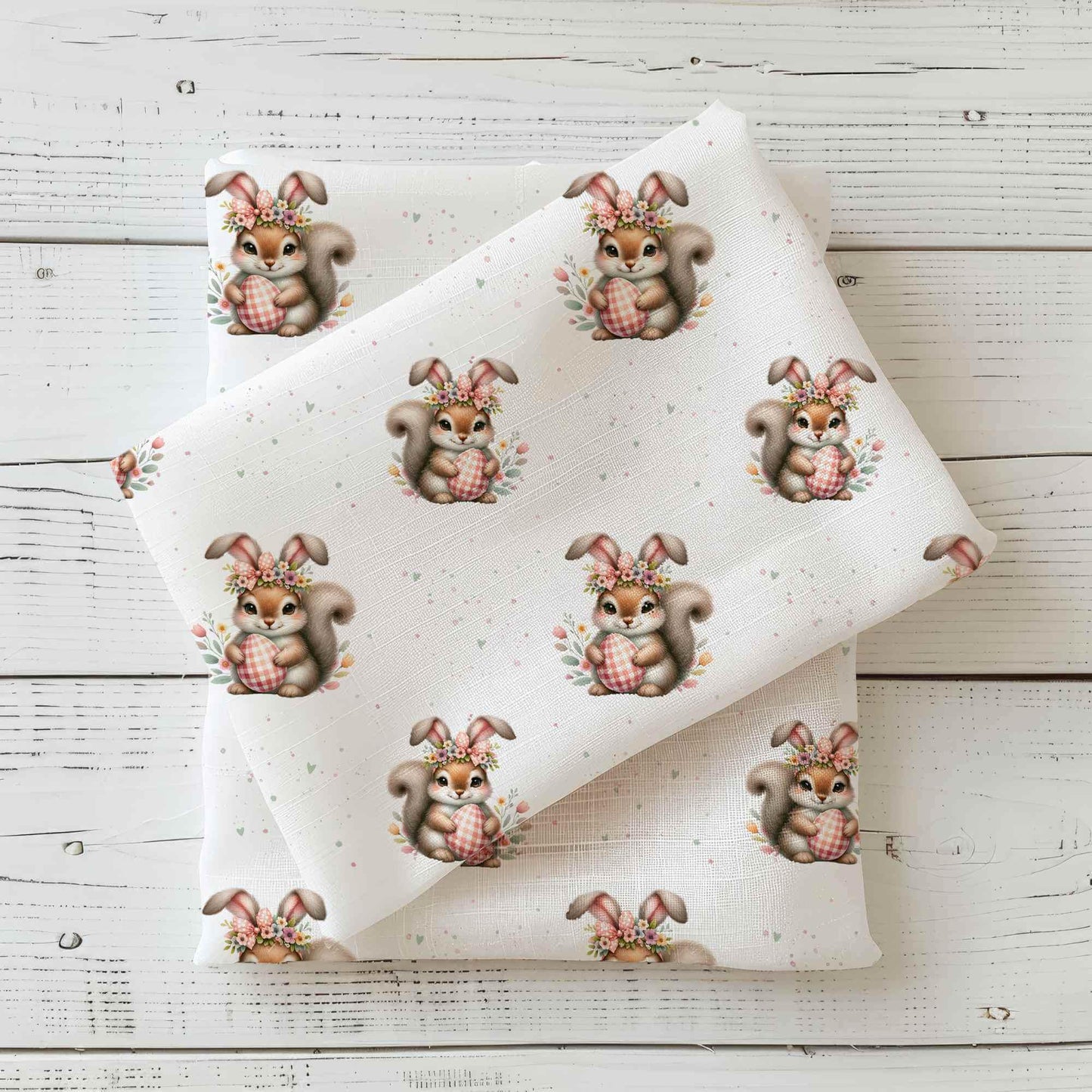 Jersey oder French Terry Stoff mit Osterhörnchen und floralen Details auf hellem Hintergrund, perfekt für kreative Nähprojekte